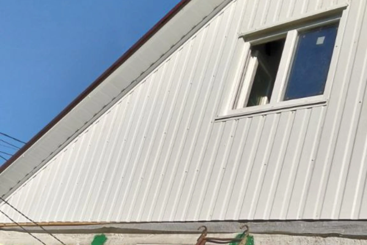 Покрівельні роботи на приватному будинку в Миколаєві — обшивка фронтону профнастилом з оформленням віконного прорізу